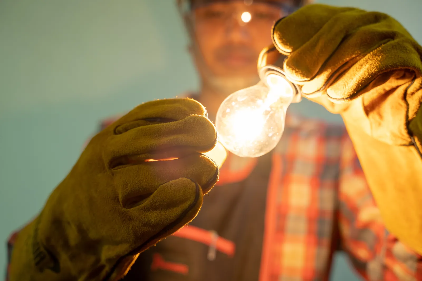 Electrician holding glowing bulb 1600